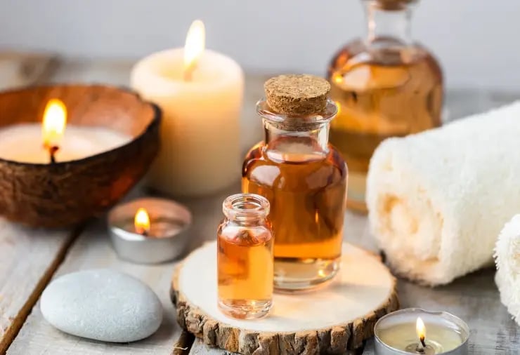 Aromatherapy massage oils and burning candle symbolizing warmth and comfort during massage.
